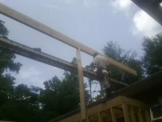 Carpenter setting a ridge beam over a new addition frame — Ice Dam Removal by Roofing Brothers in Tallassee