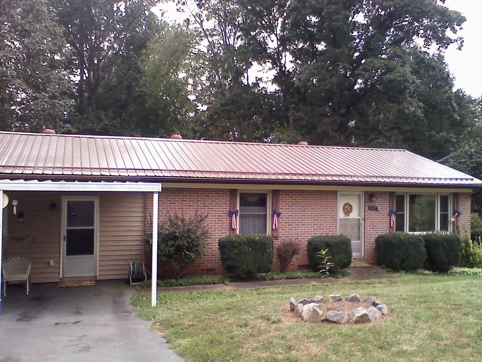 Bronze metal roof and carport on a brick ranch home — Roof Repair work by our crew in Tallassee